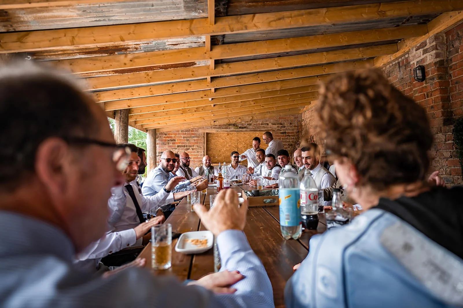 groom and groomsmen enjoy a drink in the roost at white syke fields wedding venue in yorkshire