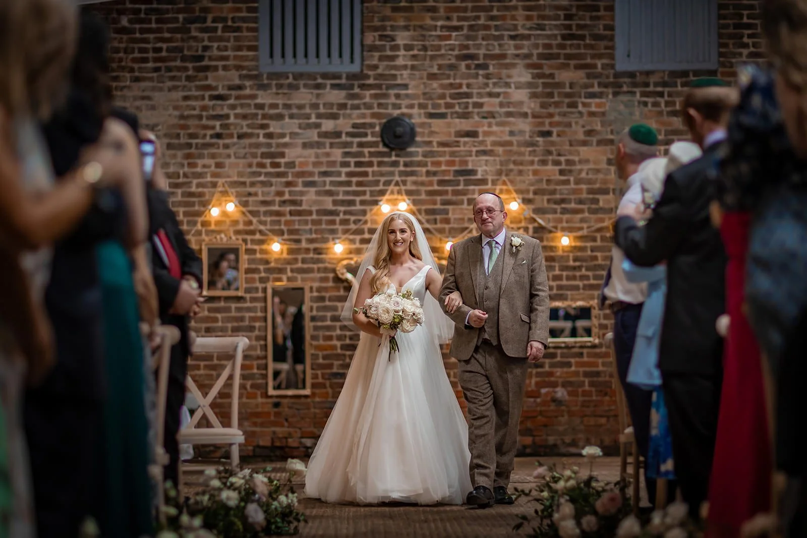 bride and father walk down aisle during wedding ceremony at white syke fields in yorkshire