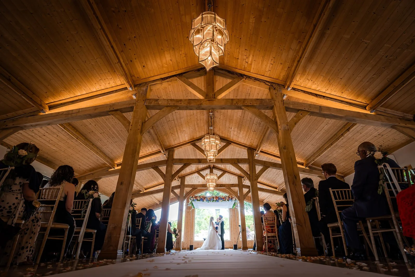 wide angle view from back of ceremony room of bride and groom exchanging vows at colshaw hall in cheshire