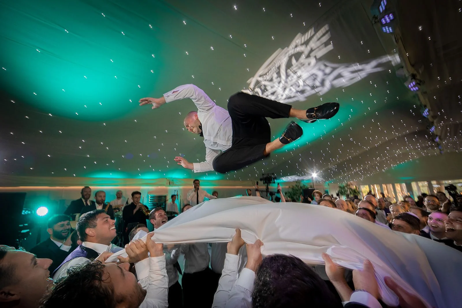 Guest lifted high during acrobatic dancing, Nunsmere Hall marquee reception
