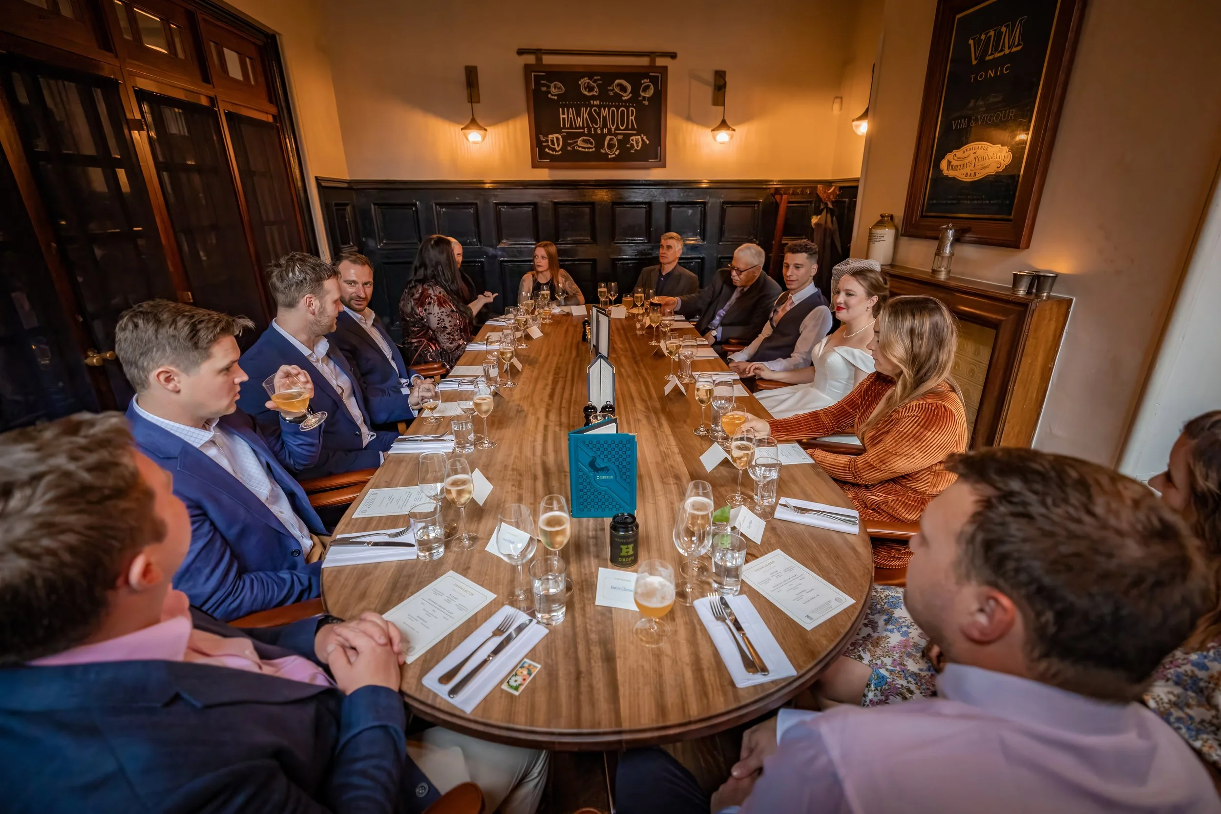 Bride and groom and guests sat around wedding breakfast table in Manchester