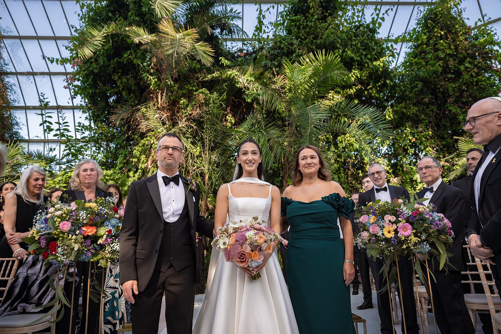 bride and parents walk down aisle at sefton park palm house wedding venue in liverpool