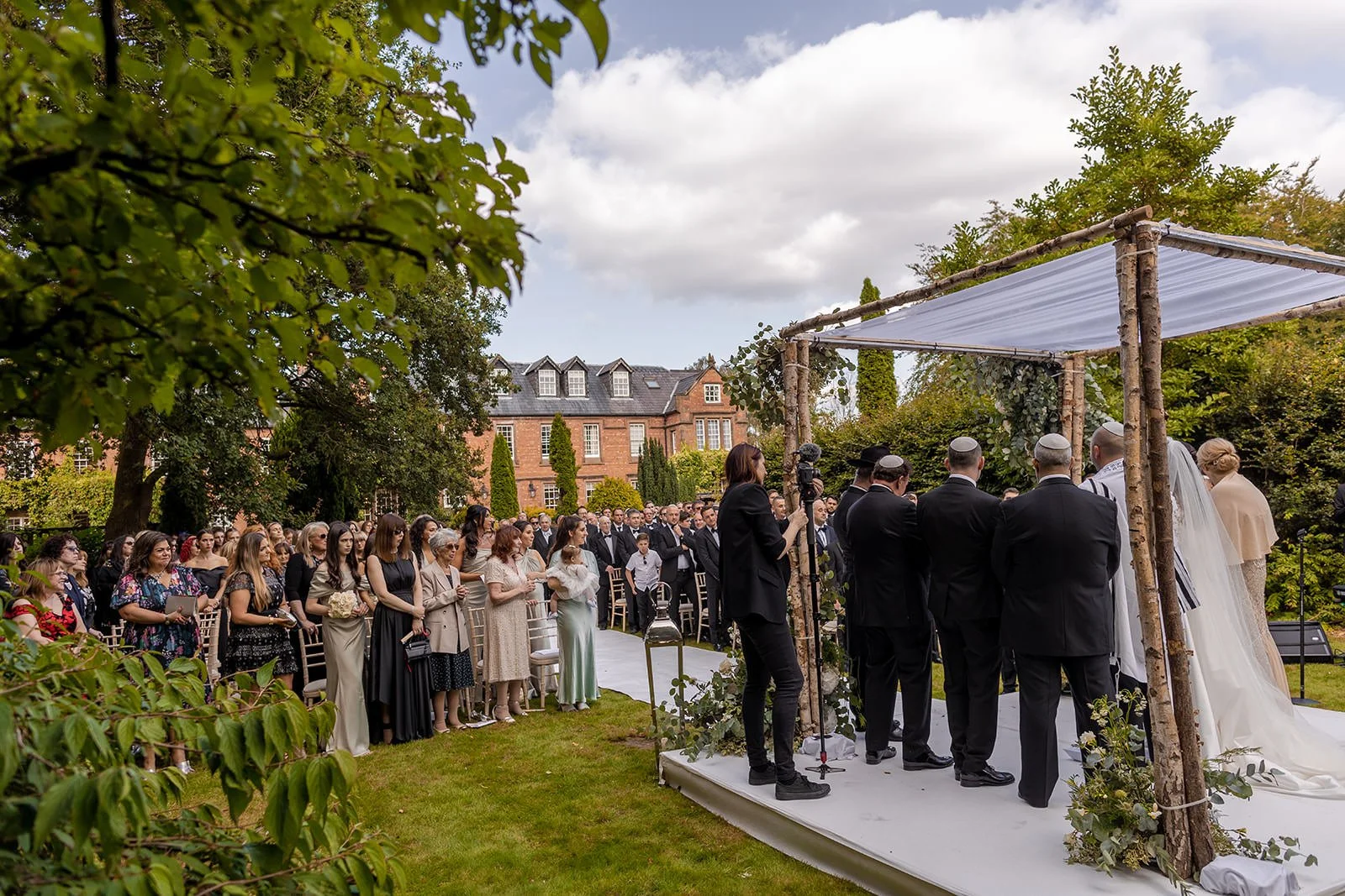 bride and groom exchange vows during outdoor wedding ceremony at nunsmere hall in cheshire