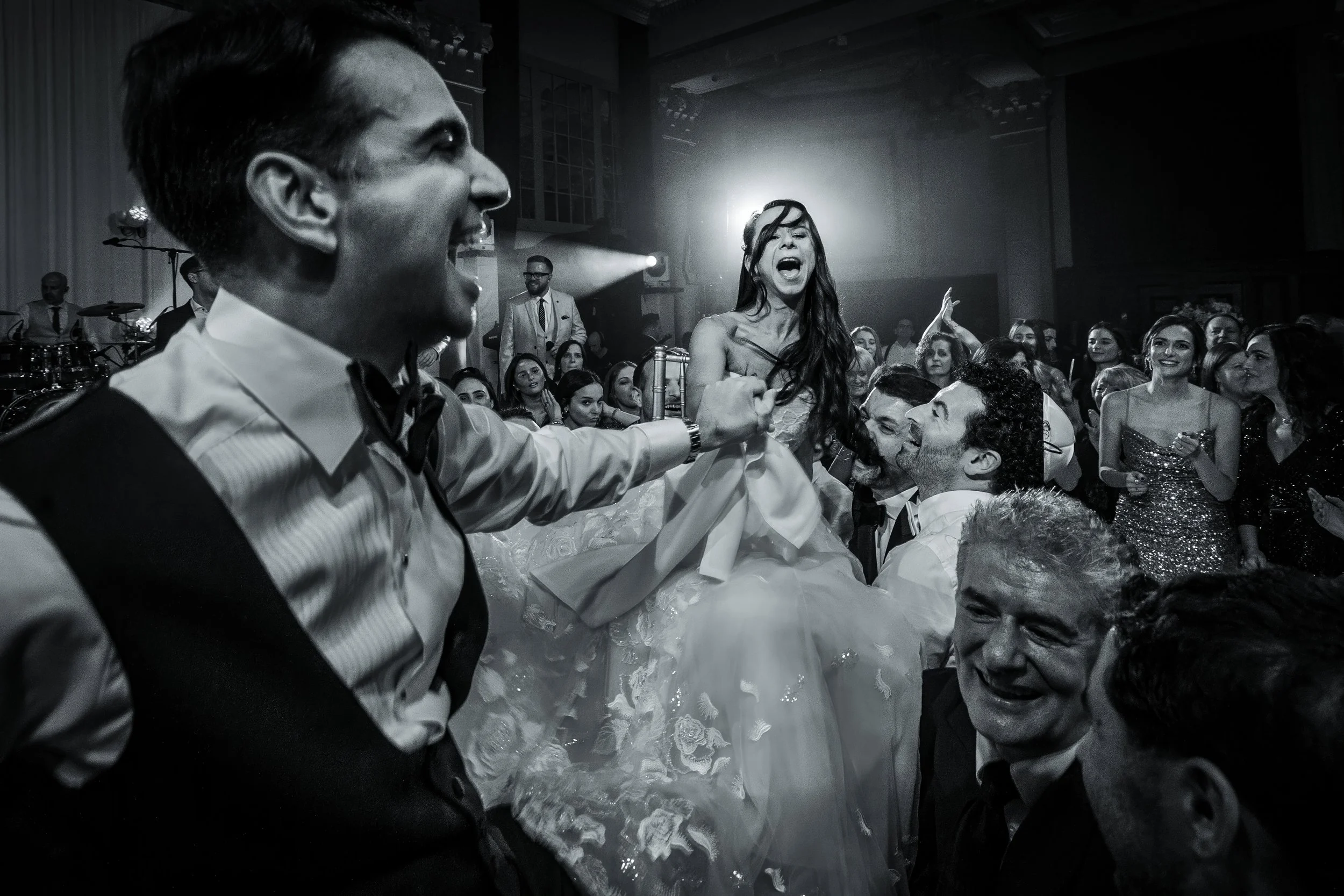 jewish bride and groom on chairs dancing on the dance floor and photographed by a Manchester wedding photographer