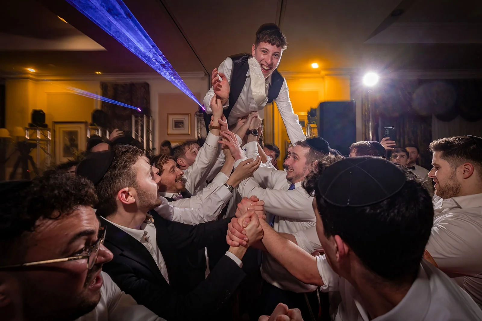 groom thrown in air during wedding party reception at last drop village in bolton