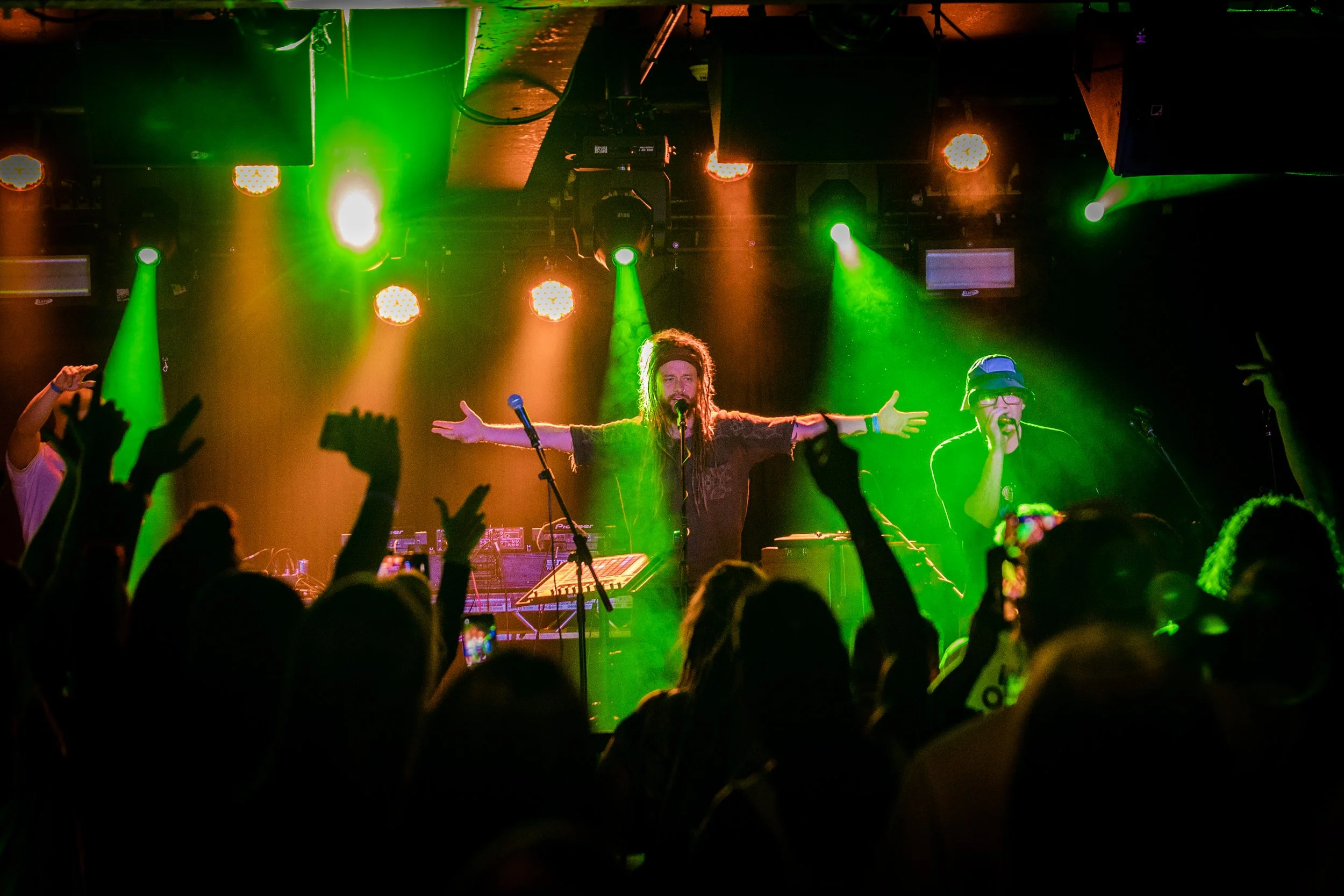 mc xander performing on stage with crowd and lights