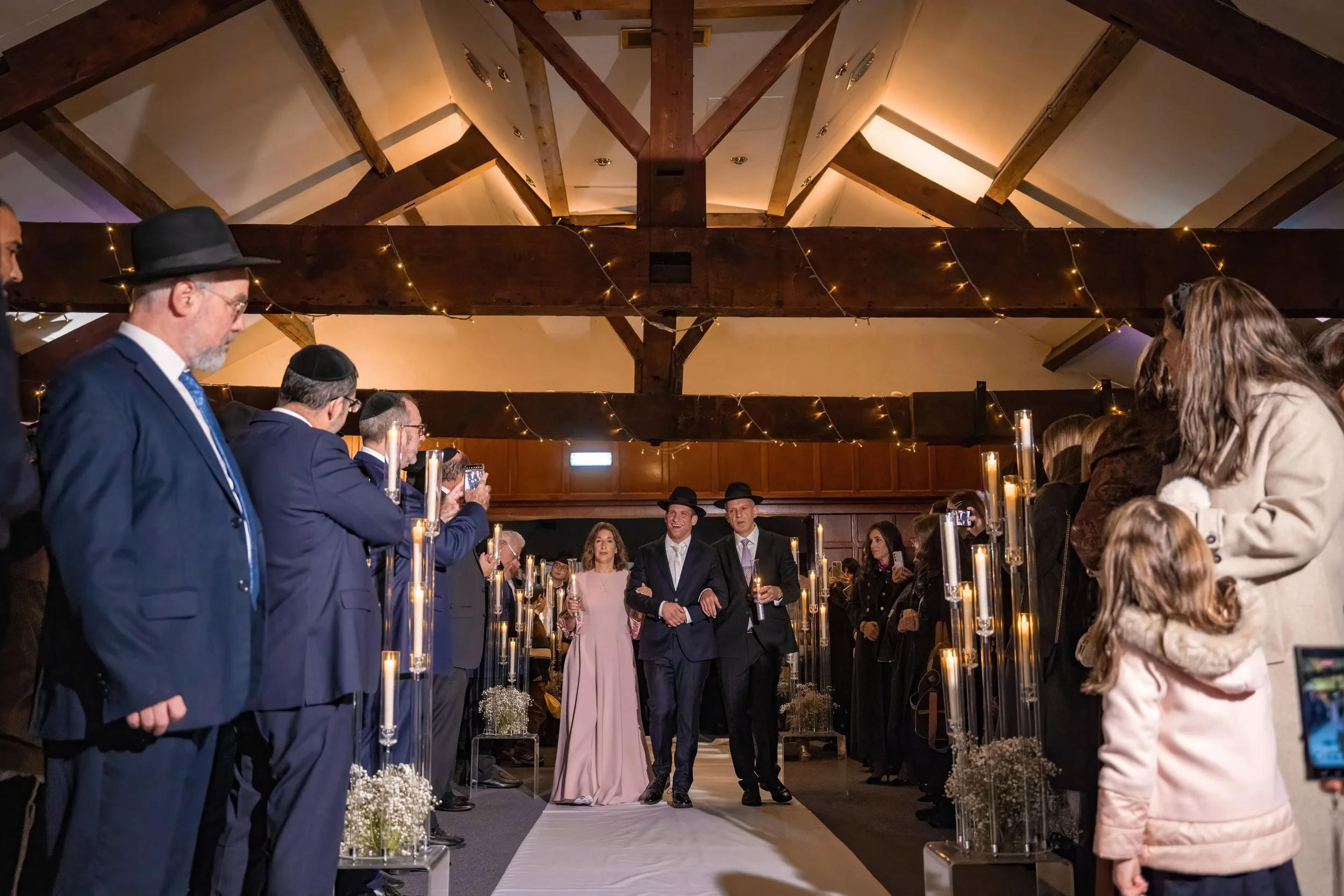 groom and parents make entrance to wedding ceremony at last drop village in bolton