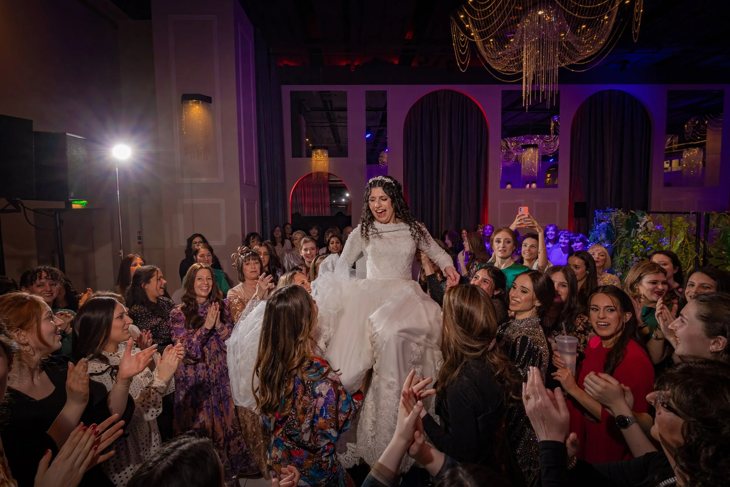kallah bride surrounded by friends on dancefloor at charedi jewish wedding