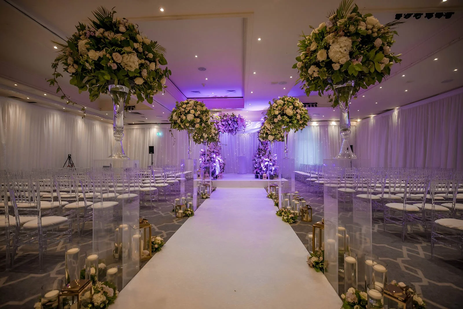 Daytime ceremony room setup with ghost chairs and floral arch, The Mere
