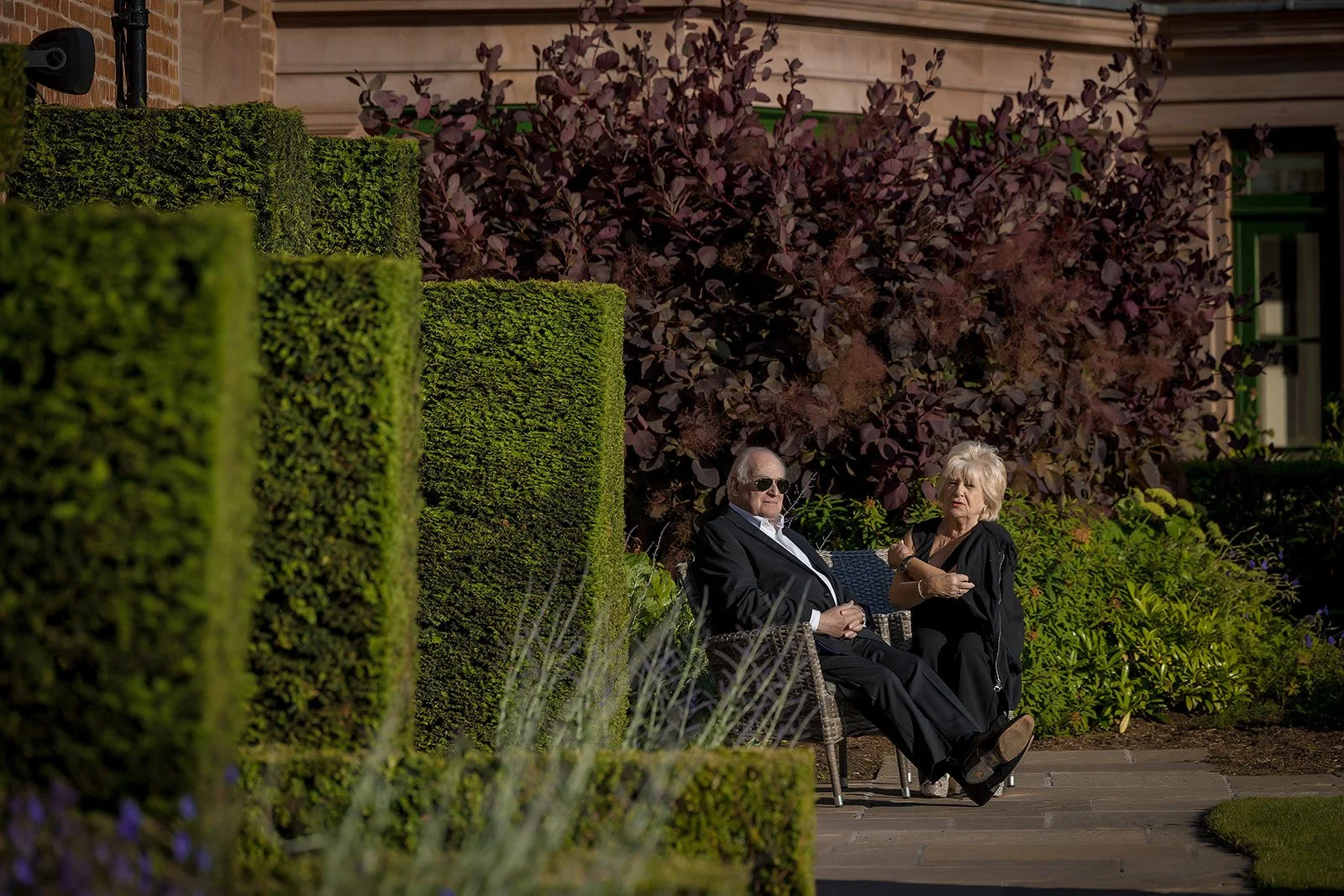 Merrydale Manor wedding guests seated in garden conversation – documentary wedding photography Manchester