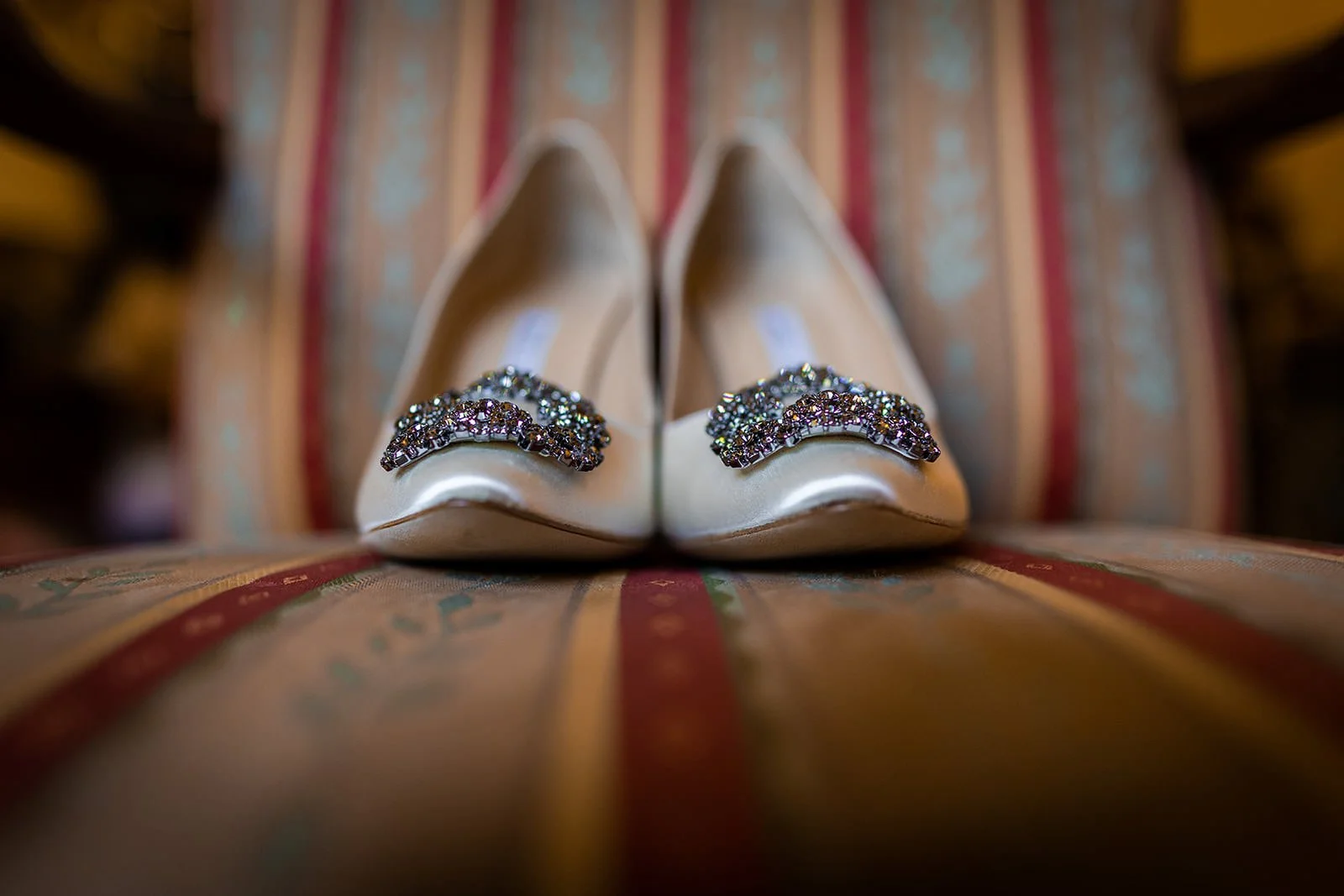 Embellished wedding shoes on patterned chair, bridal detail at Nunsmere Hall