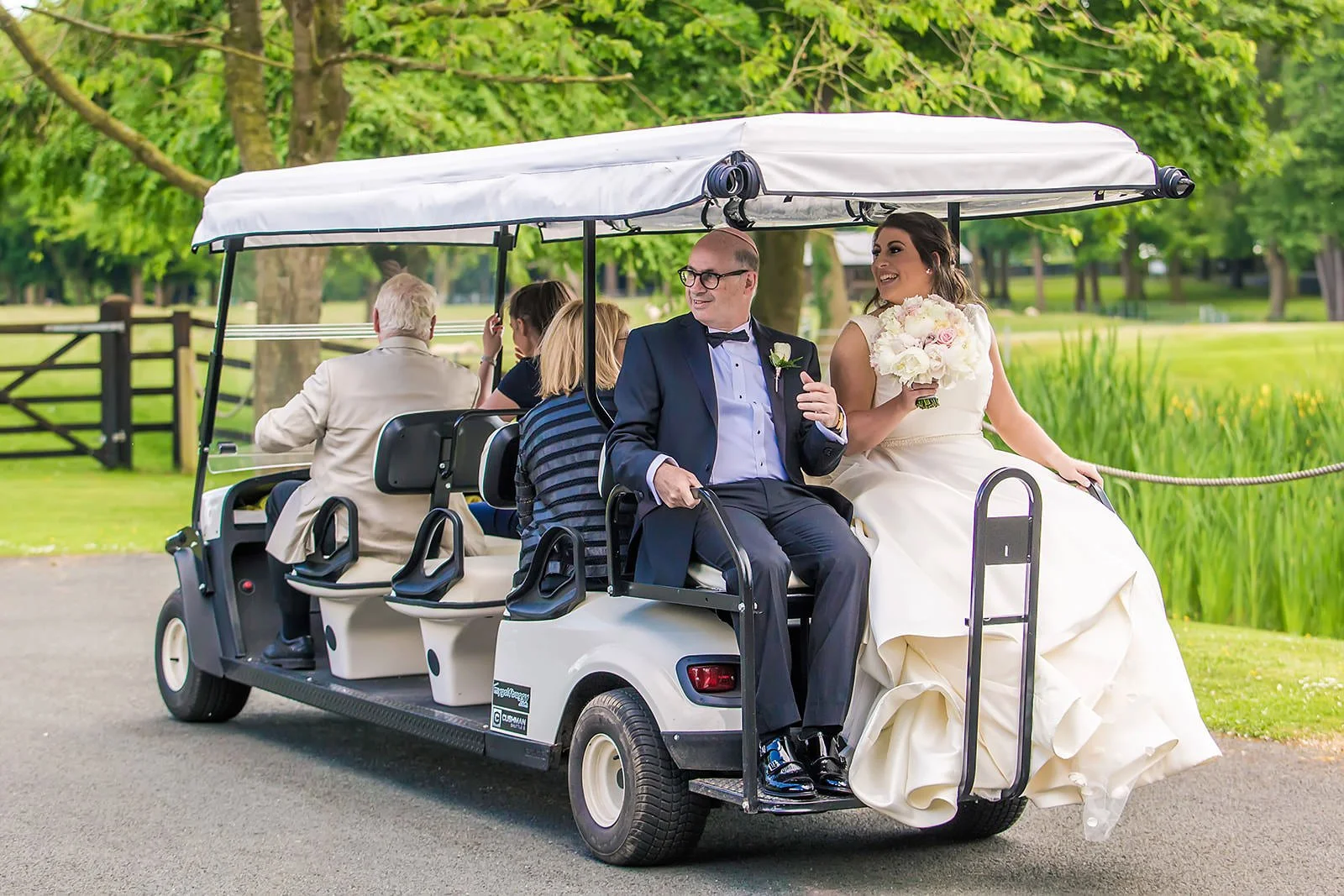bride arrival at wedding ceremony via golf buggy at colshaw hall venue in cheshire