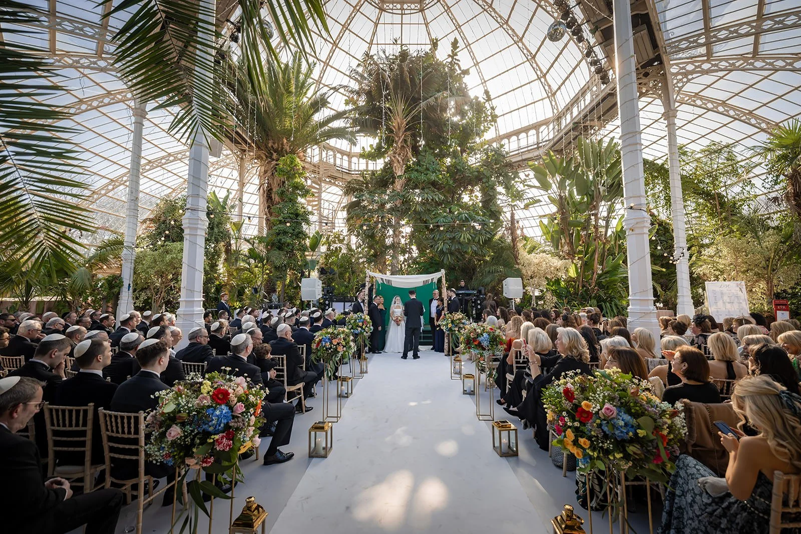 wide angle of bride and groom exchange vows during ceremony at sefton park palm house wedding venue in liverpool