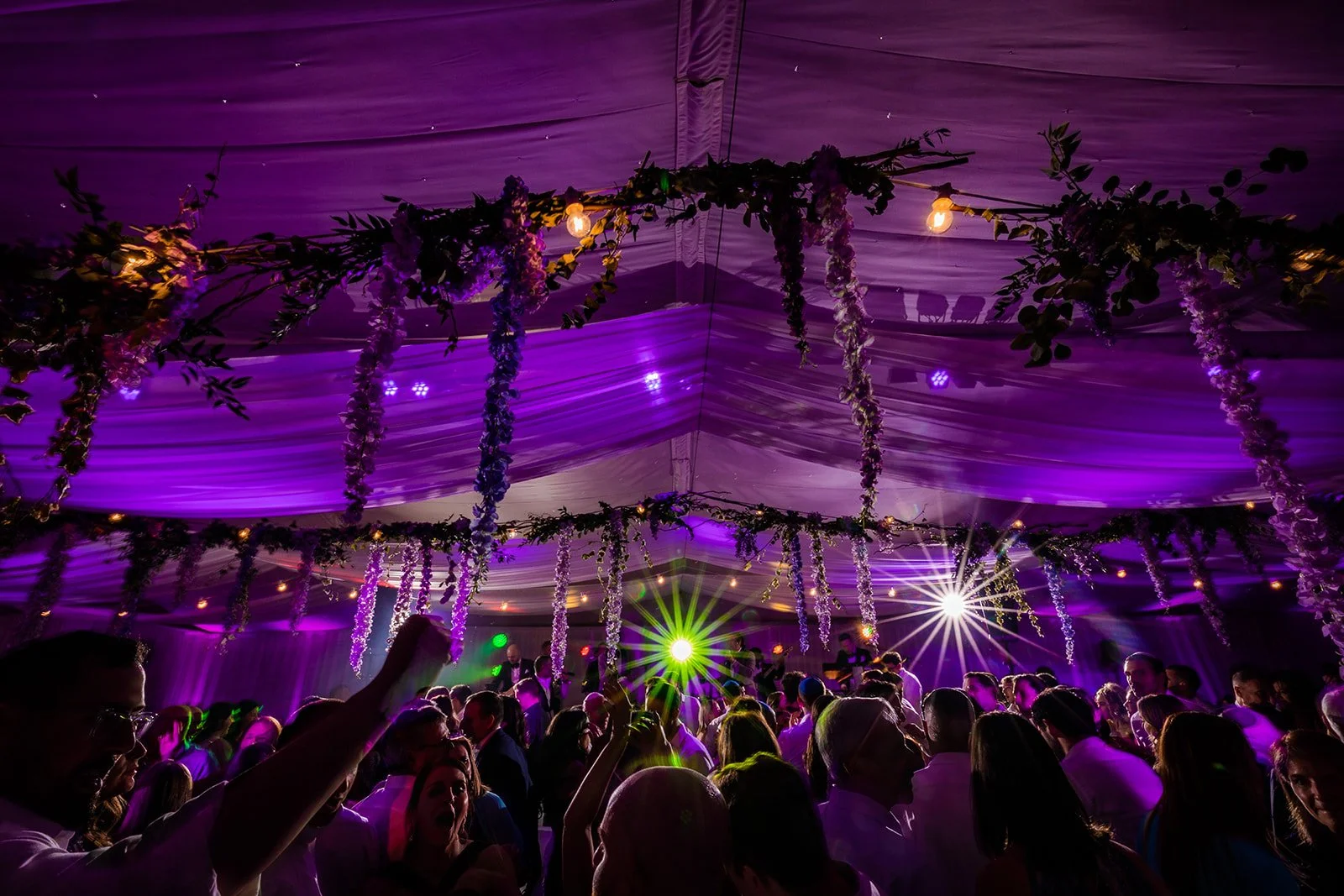 Wedding celebration in Nunsmere Hall marquee, atmospheric coloured lighting