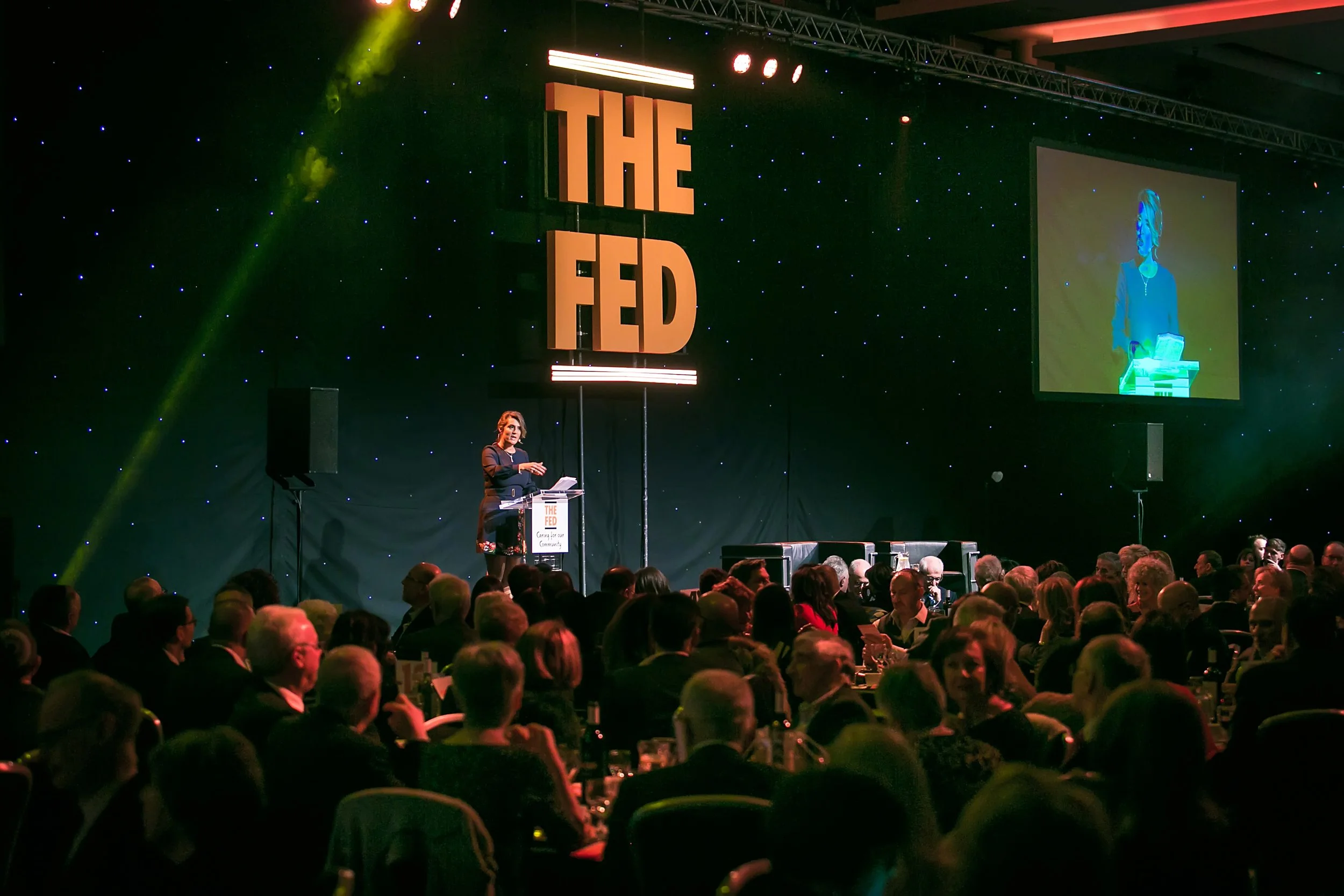 Speaker presenting on stage at a corporate event in Manchester