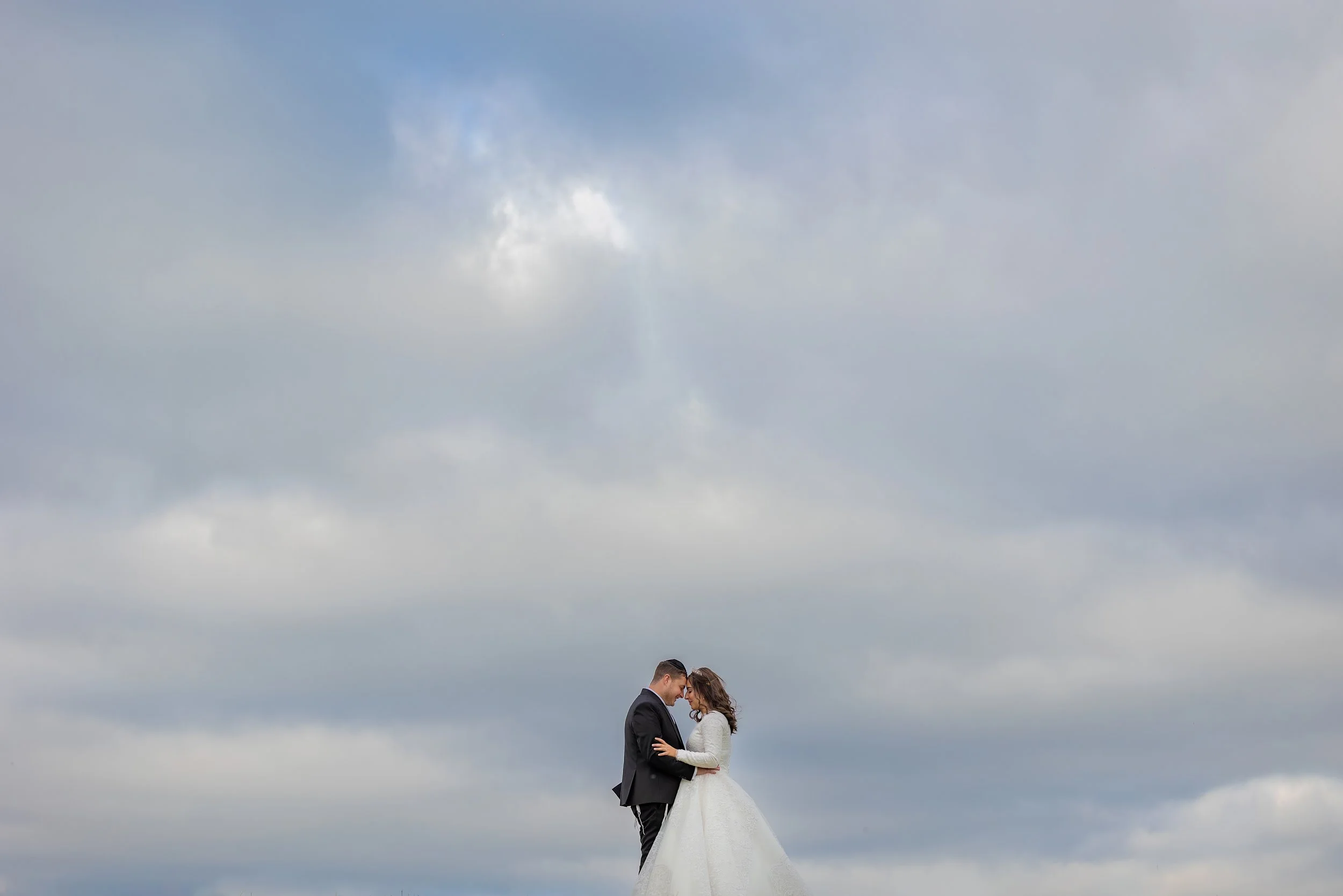 Jewish bride and groom newlywed couple portraits with sky and clouds photographed by a Manchester wedding photographer 