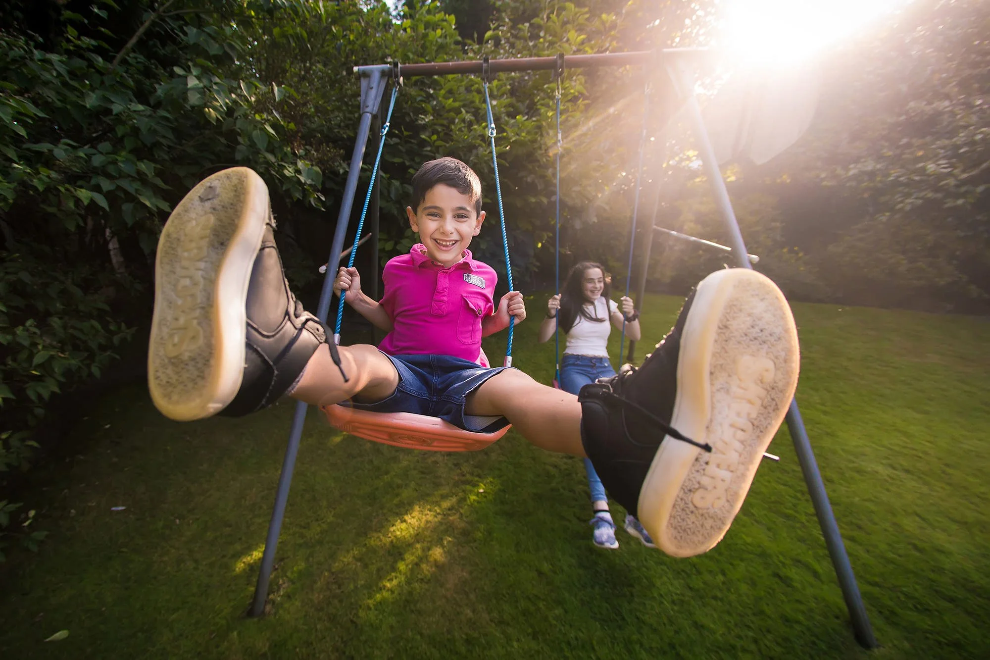 wide-angle portrait of boy on swing up close