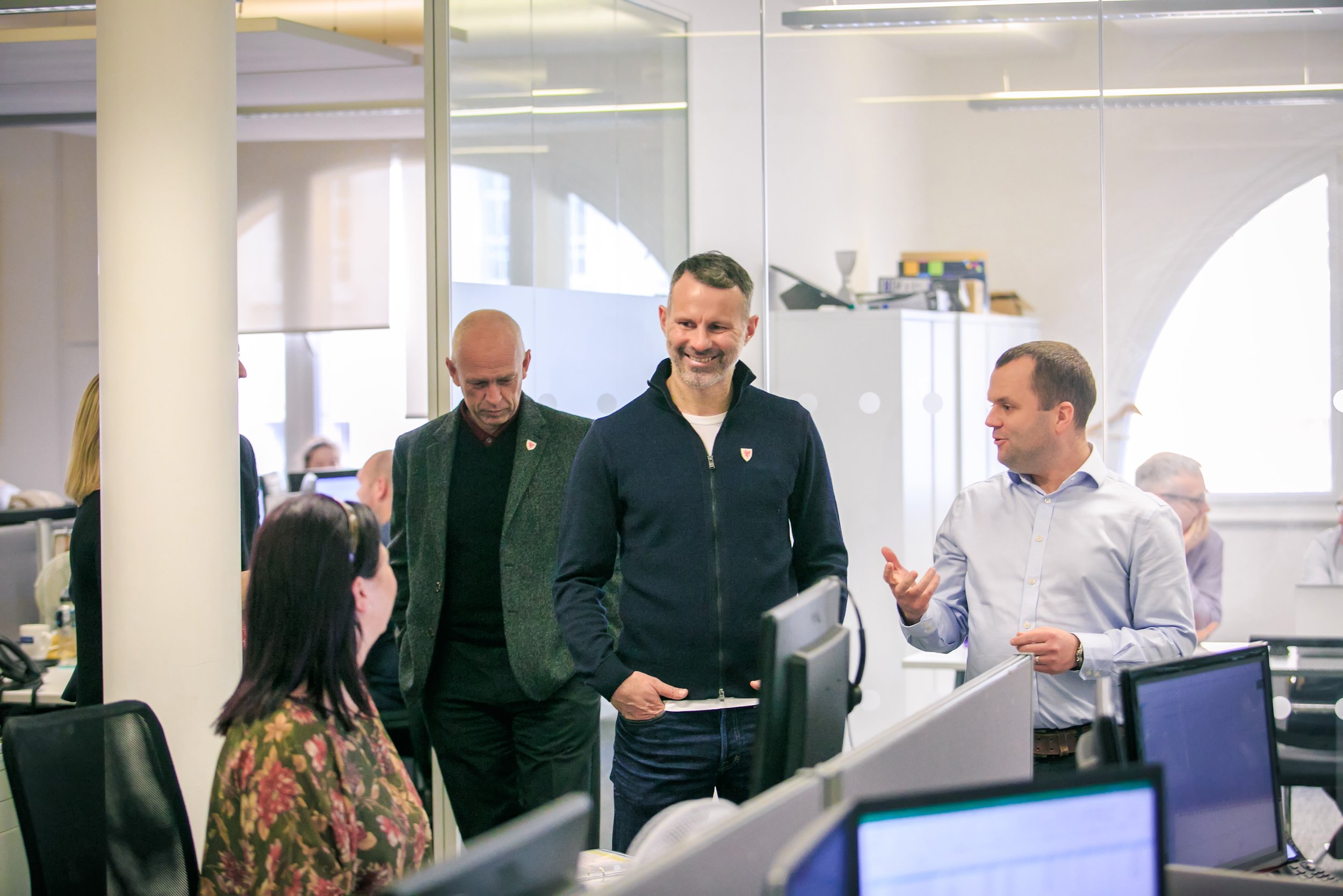 Former Manchester United footballer Ryan Giggs with corporate leadership team touring an office workplace