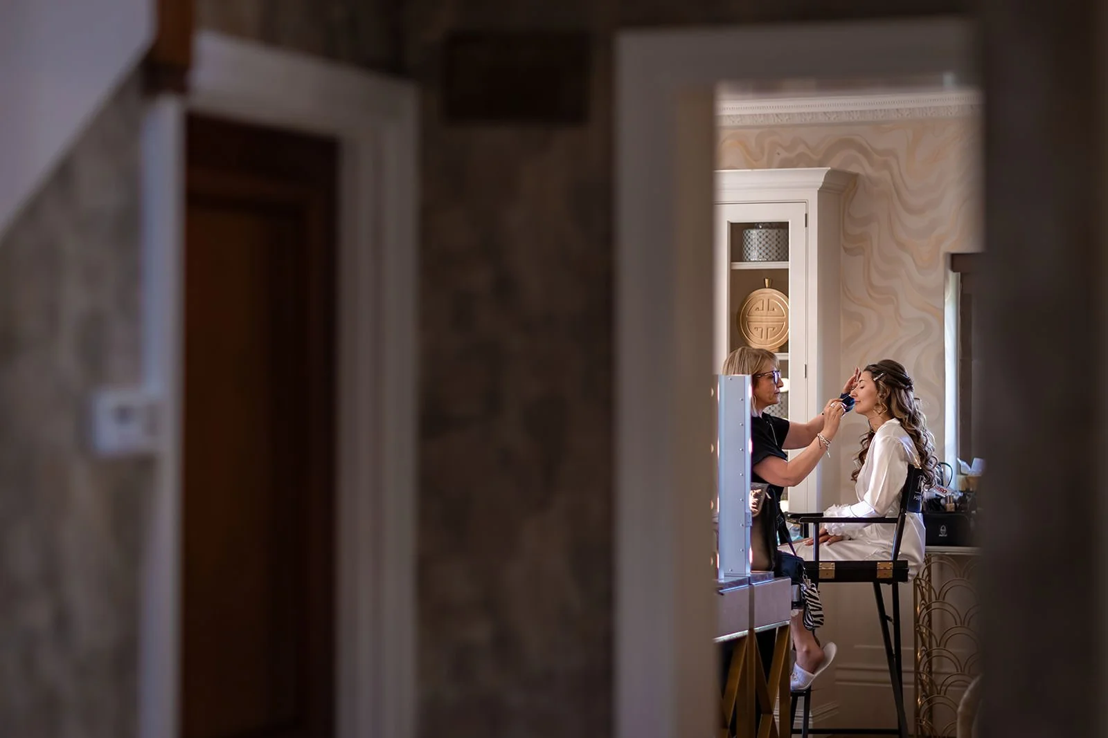 bride has make up applied during prep at colshaw hall wedding venue