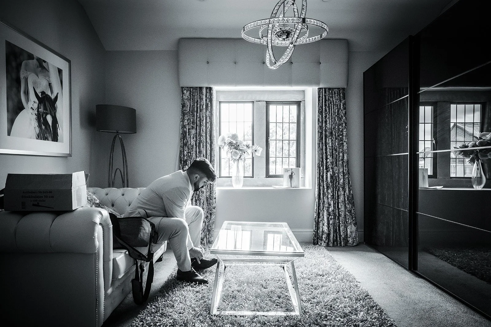 Merrydale Manor wedding groom in white suit on cream sofa – wedding photography Cheshire