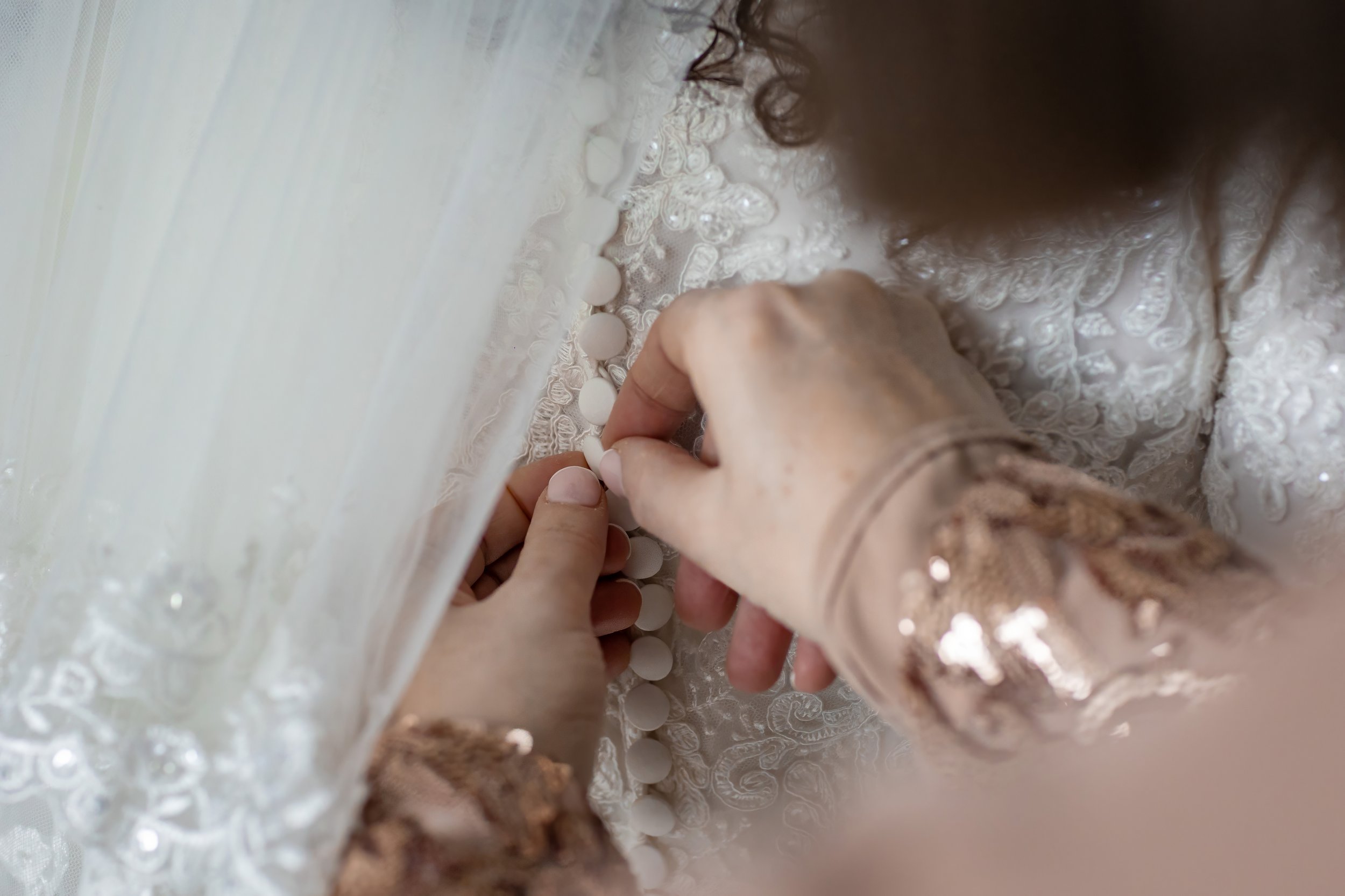 kallah bride helped into dress during prep at charedi wedding