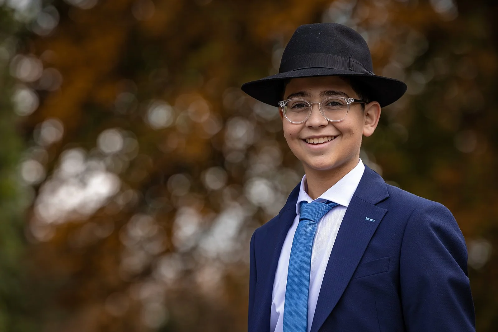 smiling barmitzvah boy portrait in shabbat suit outdoors in Manchester