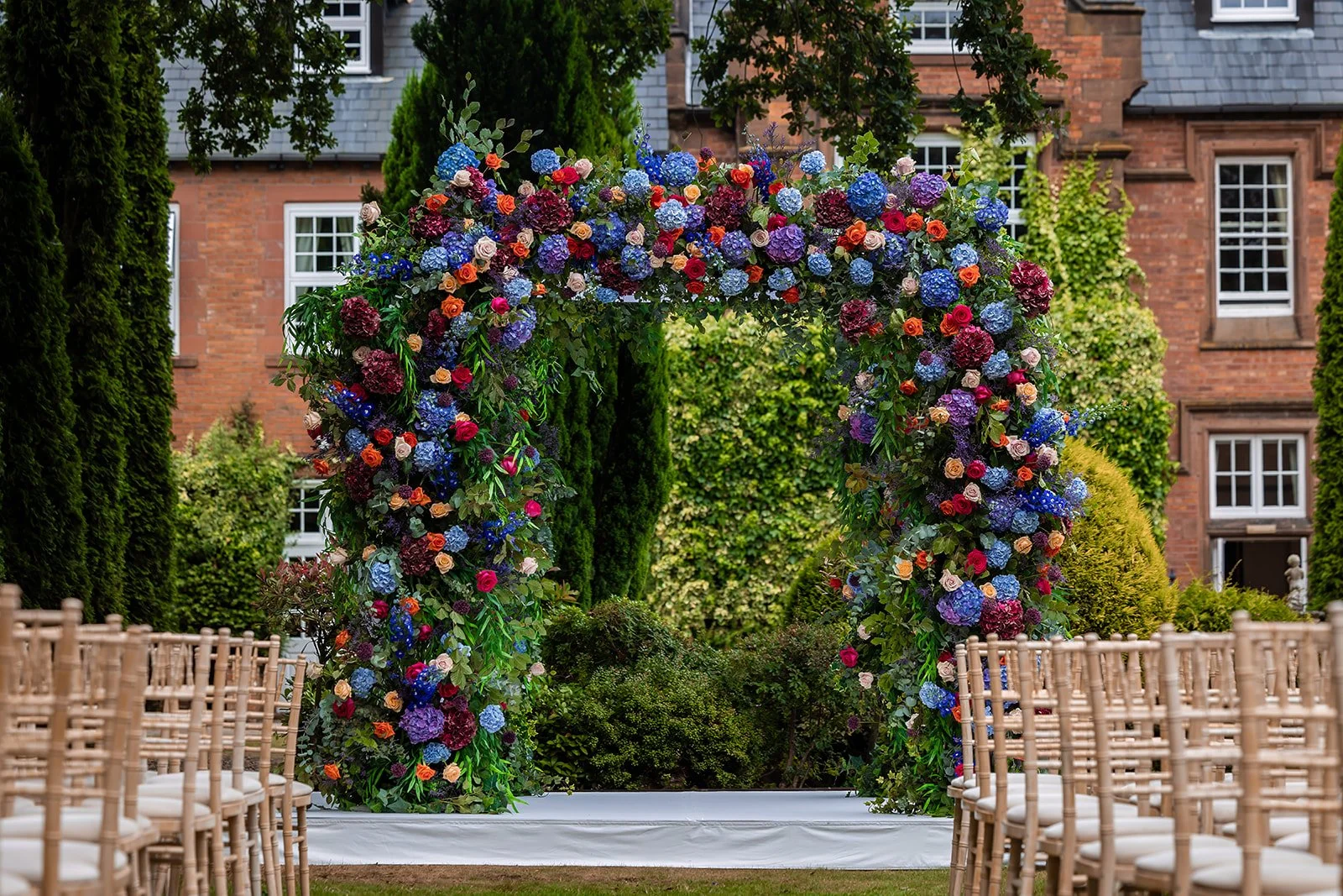 Close-up of colourful blue and purple floral chuppah at Nunsmere Hall Jewish wedding
