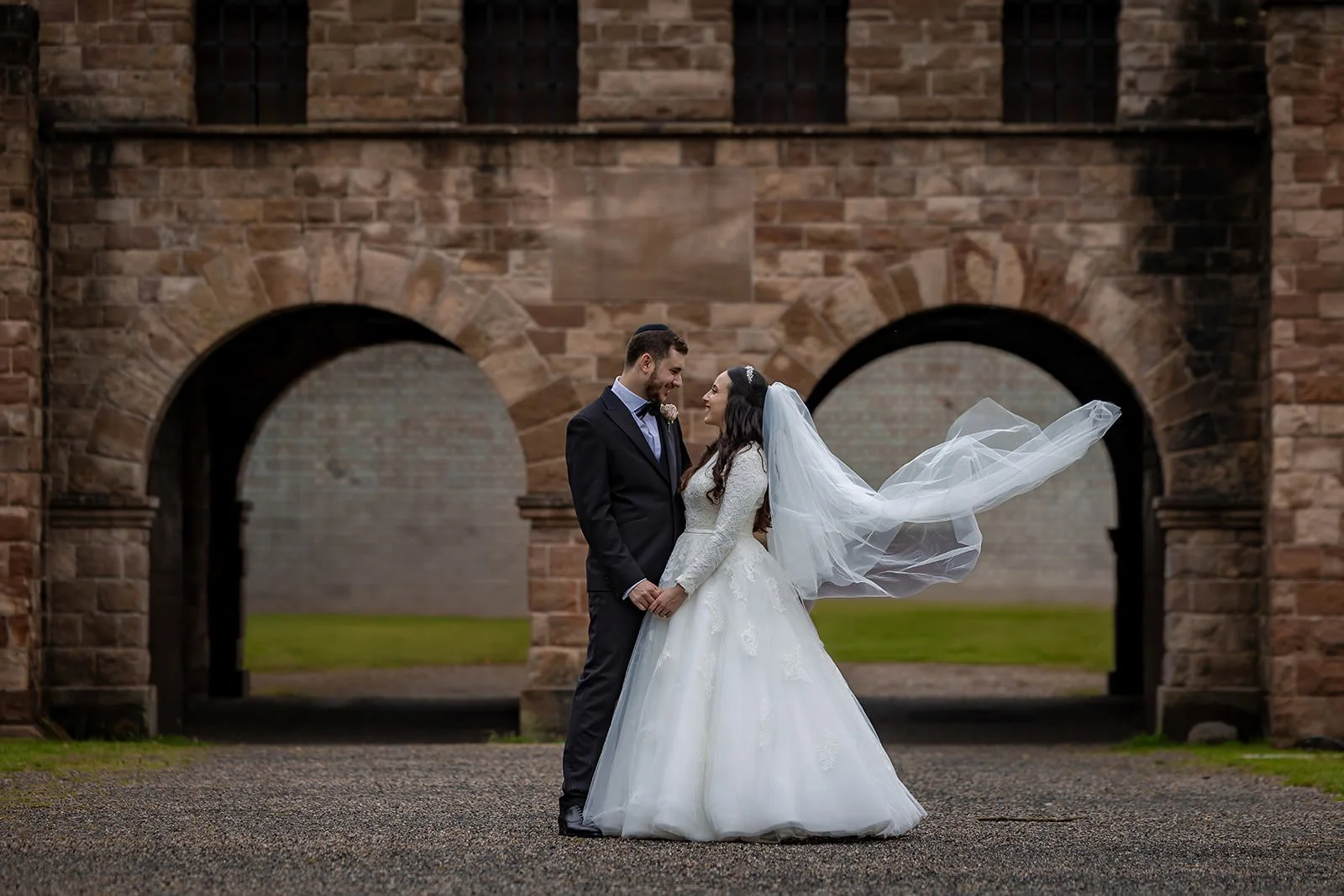 romantic newlywed bride and groom couple portrait with veil flowing outside manchester deansgate hotel in castlefield