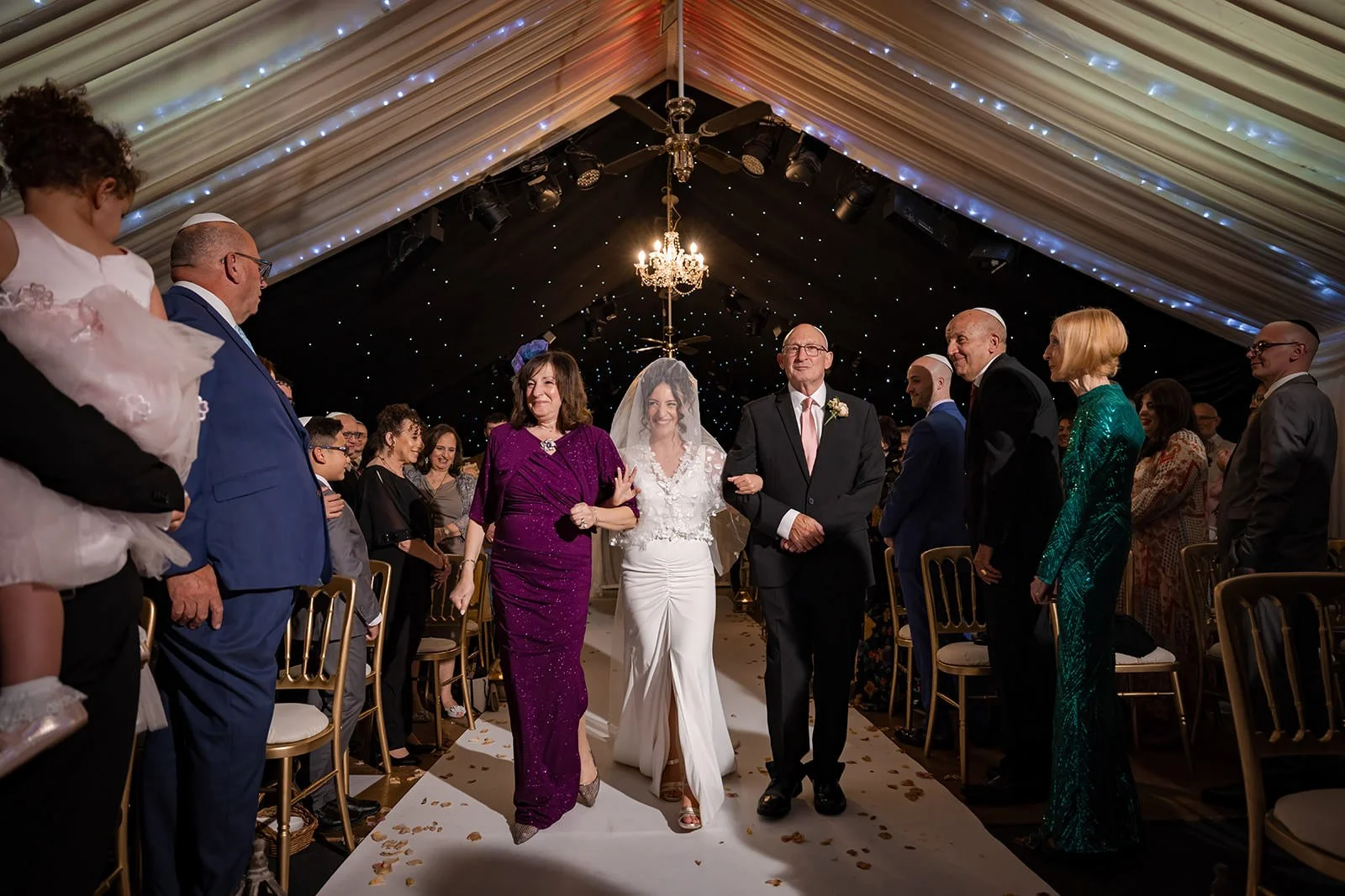 bride and father walk down aisle during wedding ceremony at heaton house farm in macclesfield