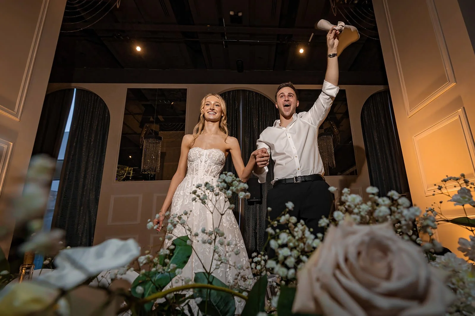 bride and groom dancing on chairs during wedding reception party at mercure manchester piccadilly