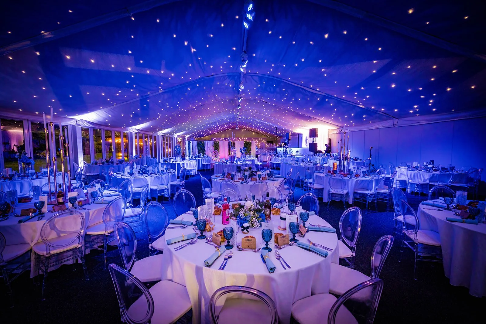 Nunsmere Hall marquee dinner setup with starlit canopy and blue lighting
