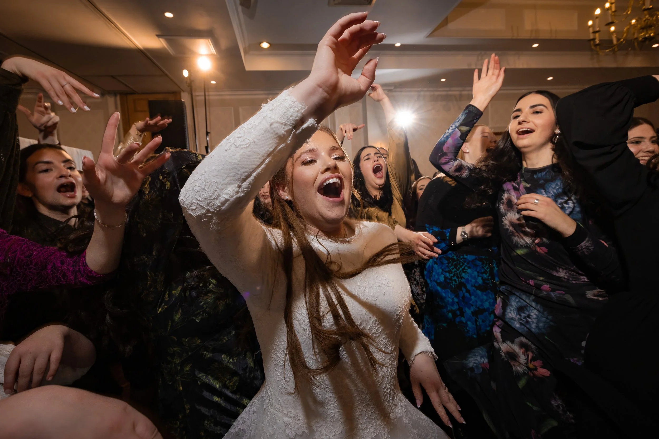 kallah bride surrounded by friends on dancefloor at charedi jewish wedding