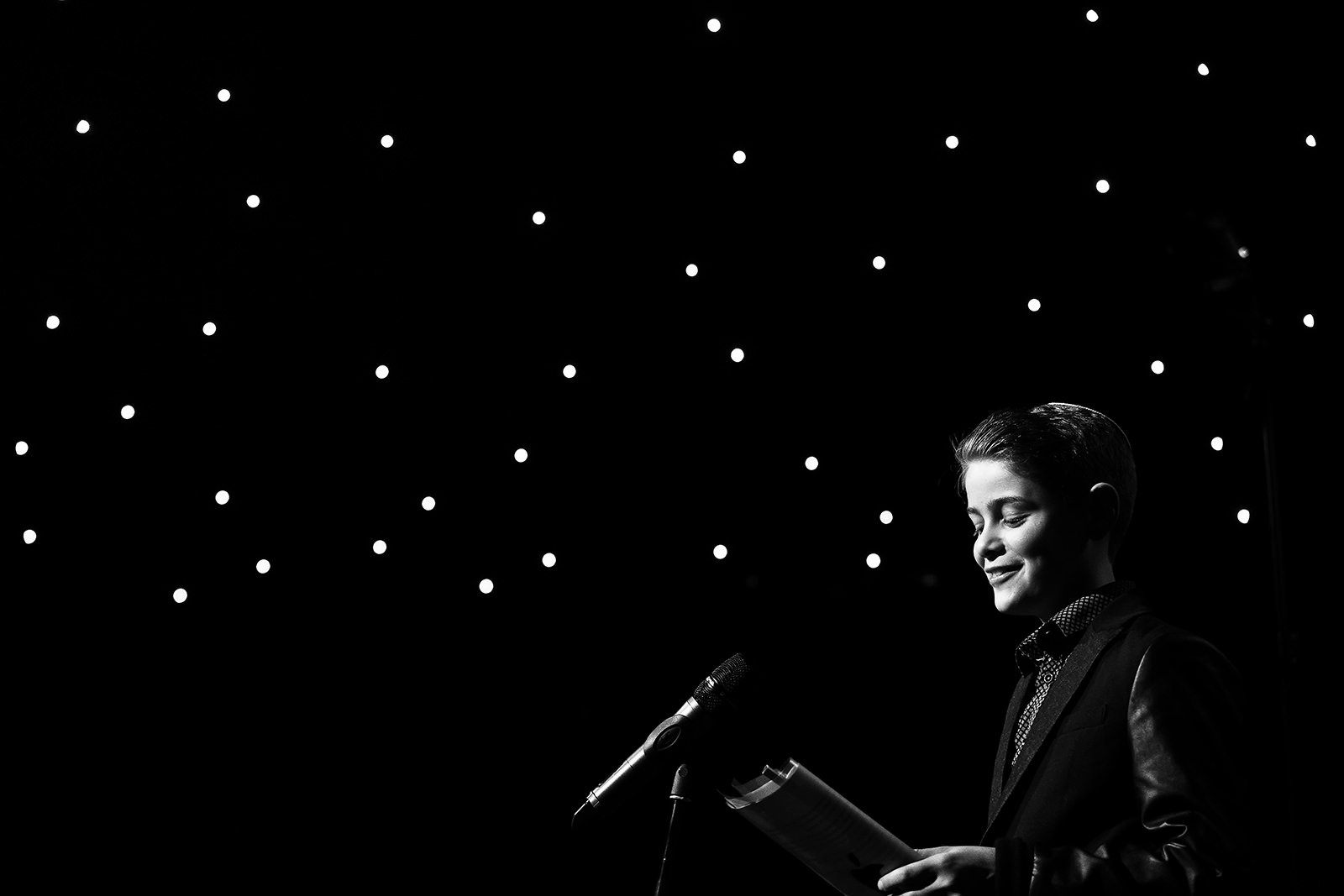 black and white of barmitzvah boy delivering speech with star backdrop