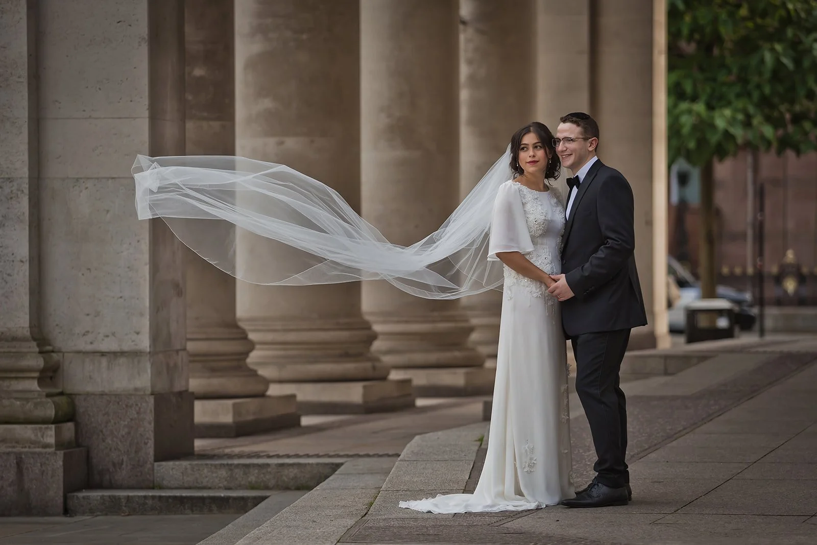 bride and groom newlywed couple portrait with flowing veil outside manchester central library