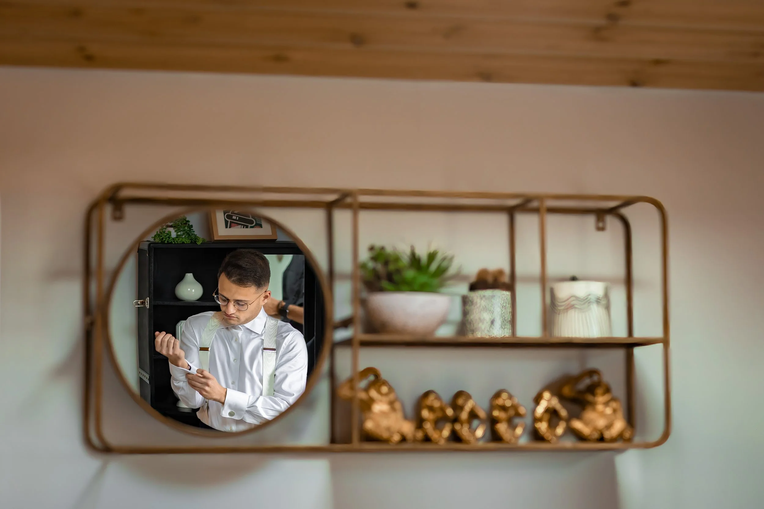 Merrydale Manor wedding groom checking phone in round mirror – fine art wedding photographer North West