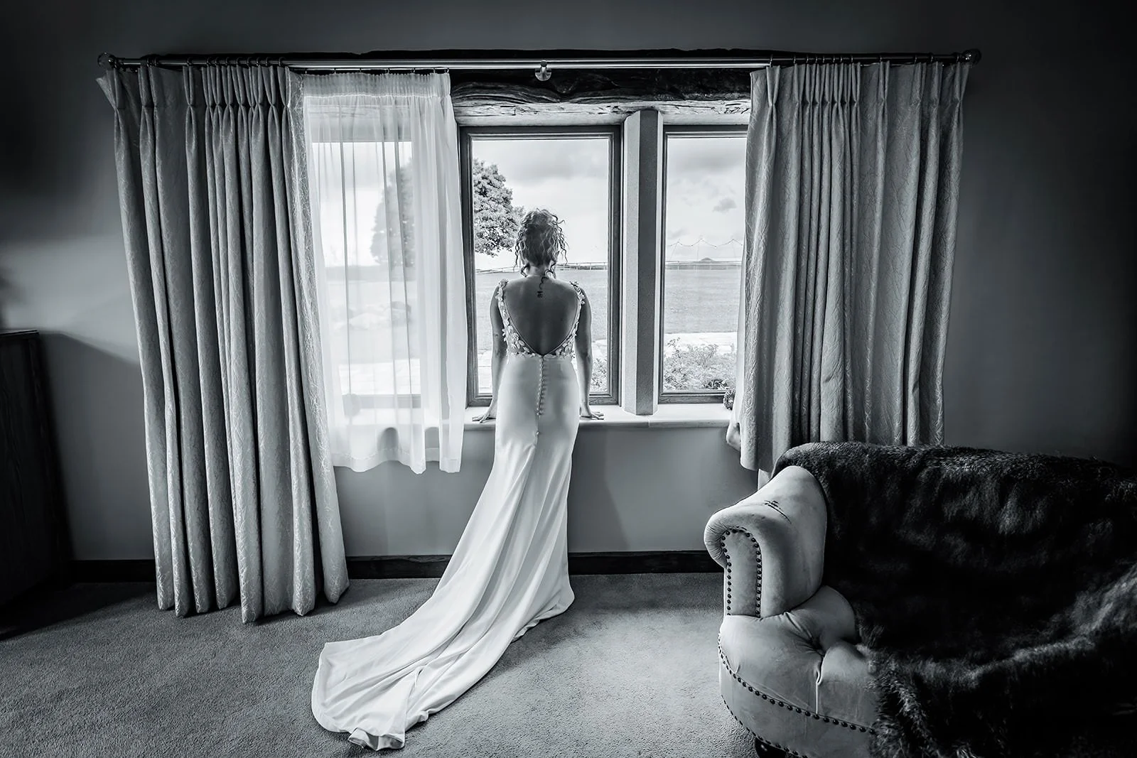 bridal looks out window at prep at heaton house farm wedding venue in macclesfield
