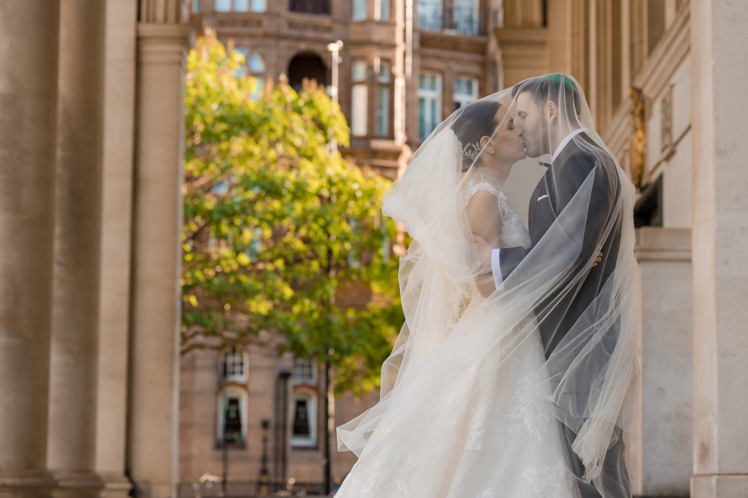 bride and groom newlywed couple portrait wrapped in veil in manchester city center