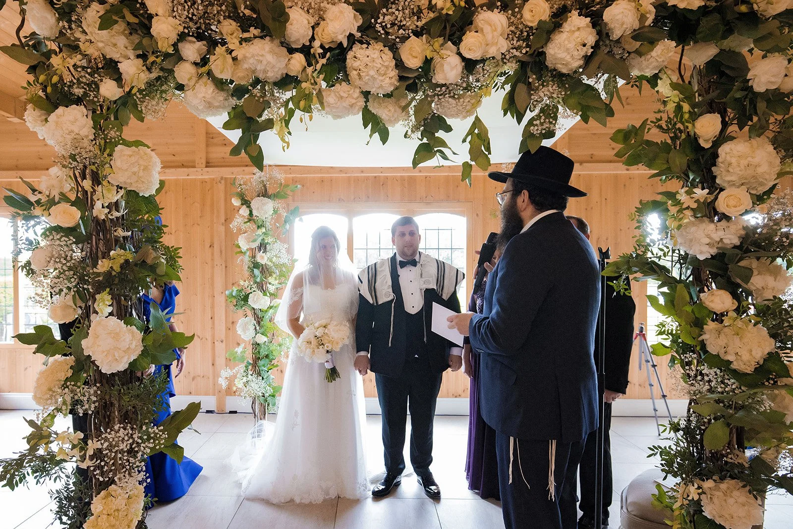 Merrydale Manor wedding couple holding hands under floral arch – fine art wedding photographer North West
