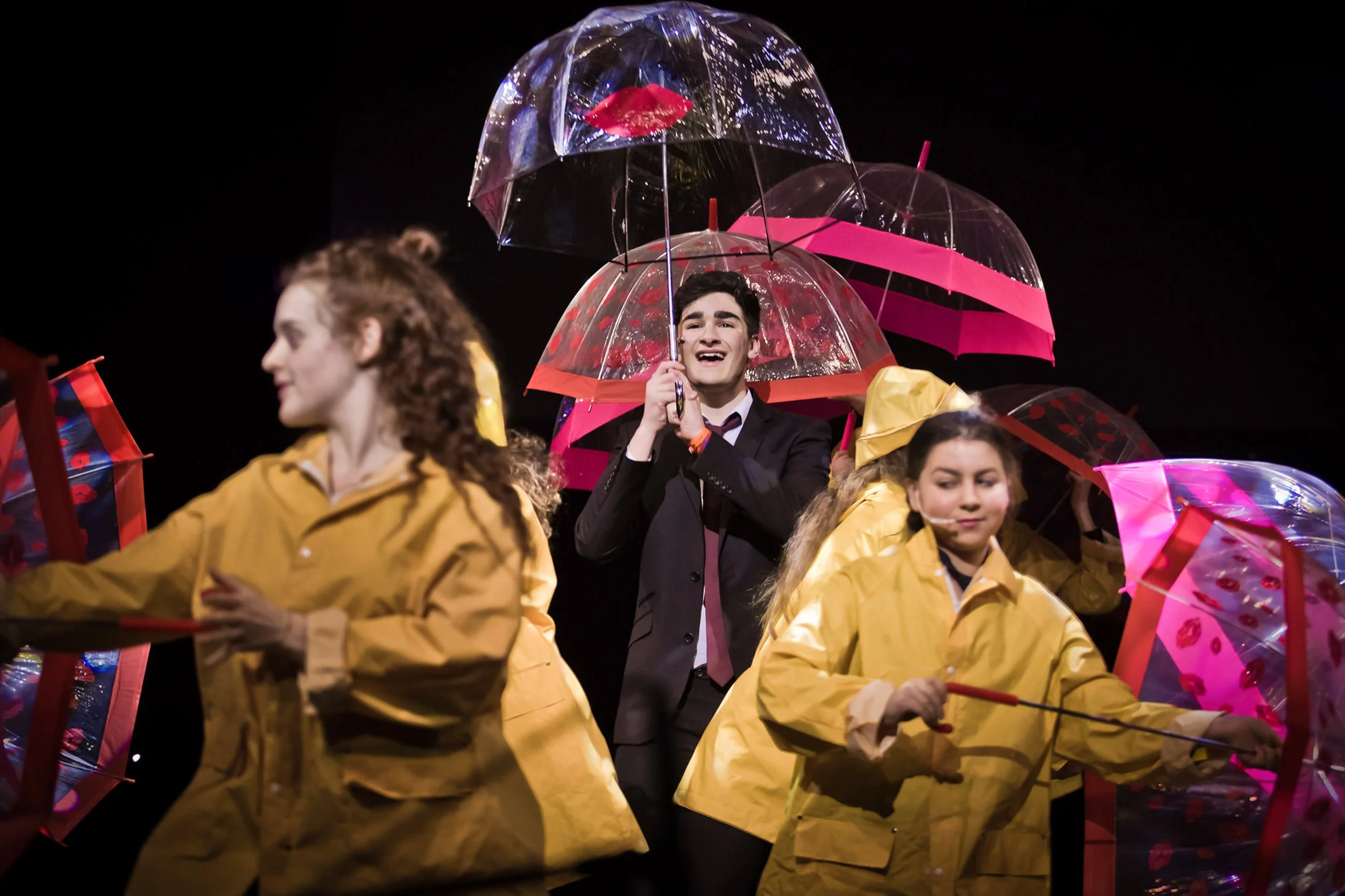 singing in the rain school production stage photography with umbrellas