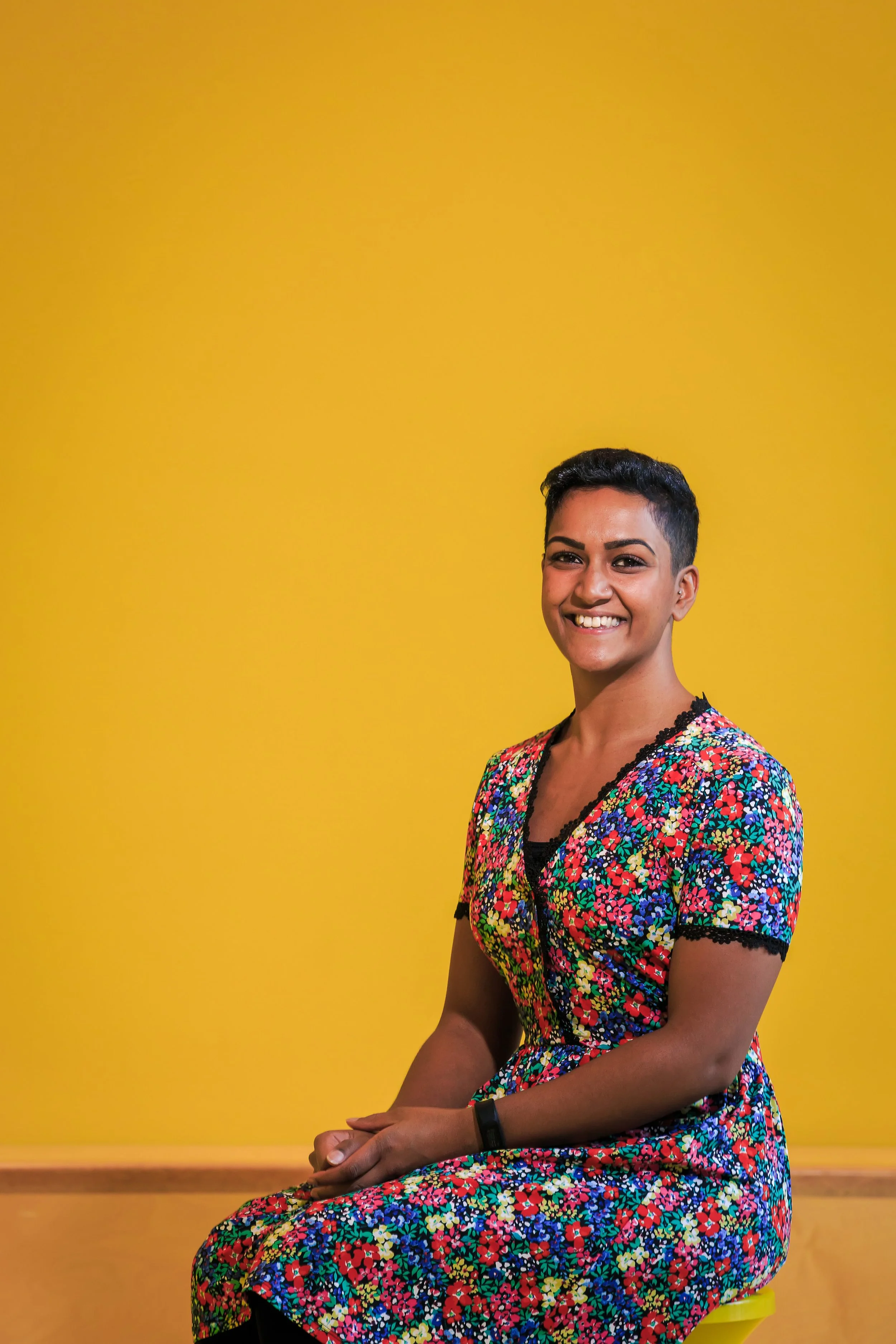 Corporate headshot against a colourful yellow studio background