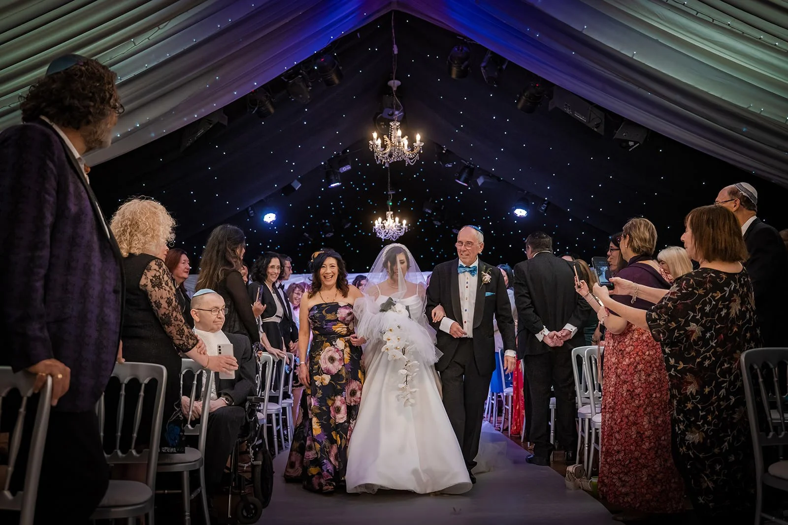 bride and father walk down aisle during wedding ceremony at heaton house farm in macclesfield
