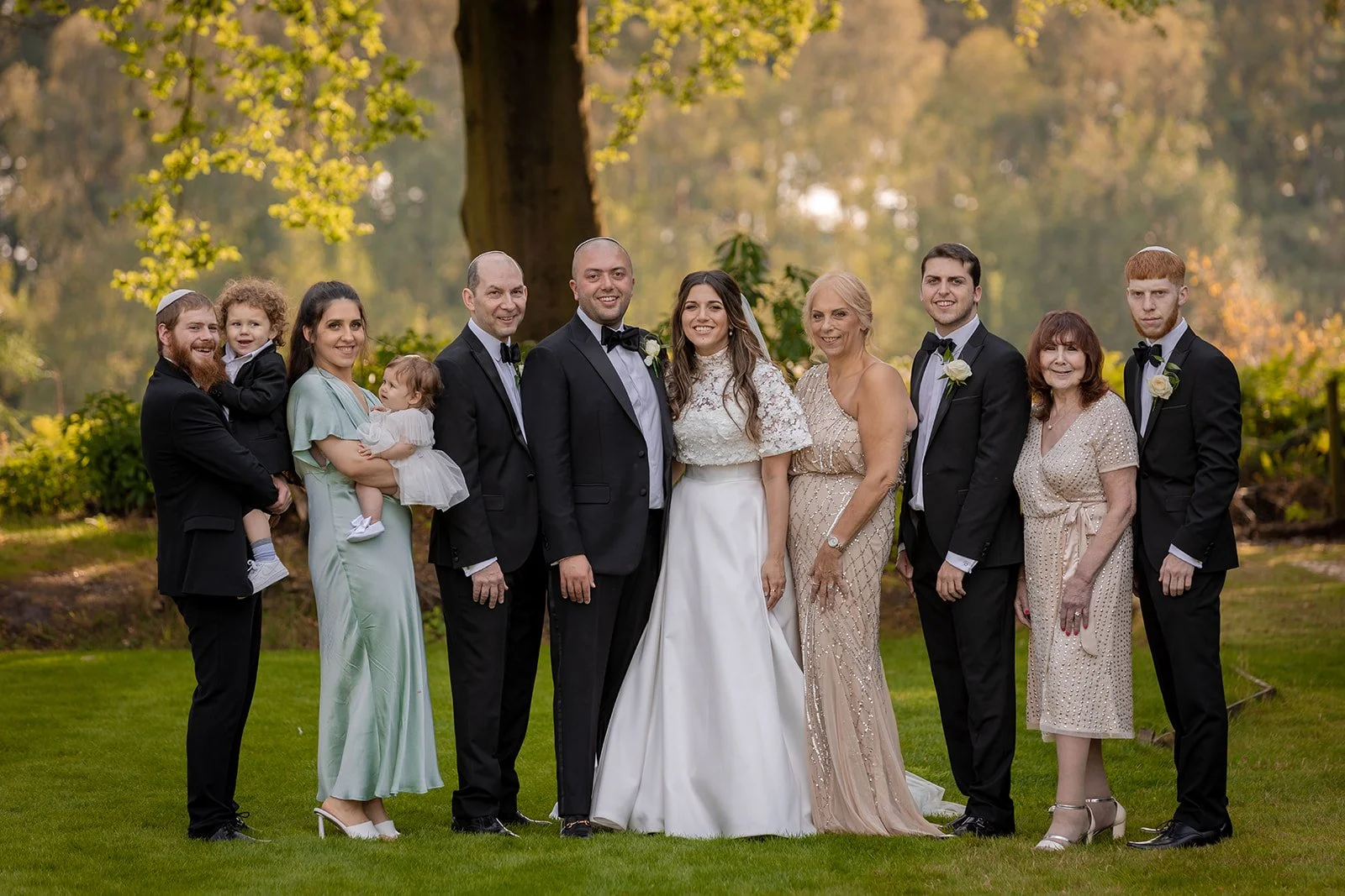 Family group photograph on the lawn at Nunsmere Hall in golden hour light
