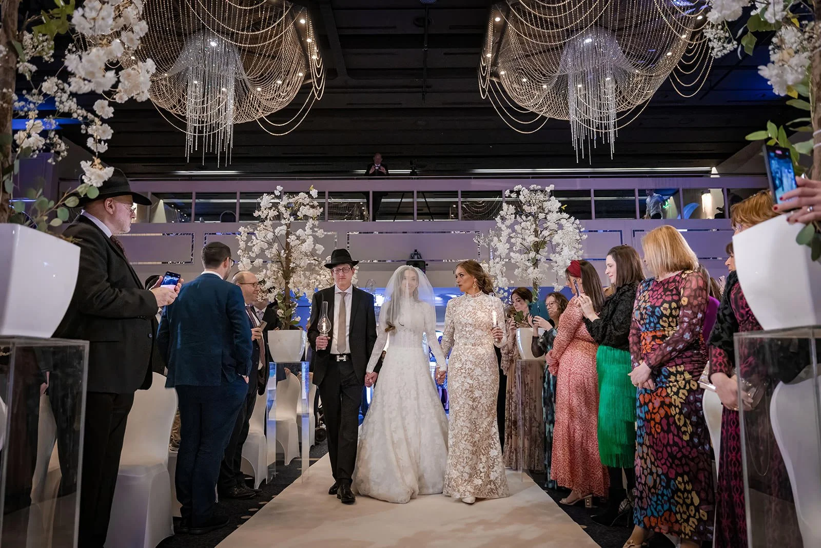 bride and parents walk down aisle during wedding ceremony in international suite at mercure manchester piccadilly