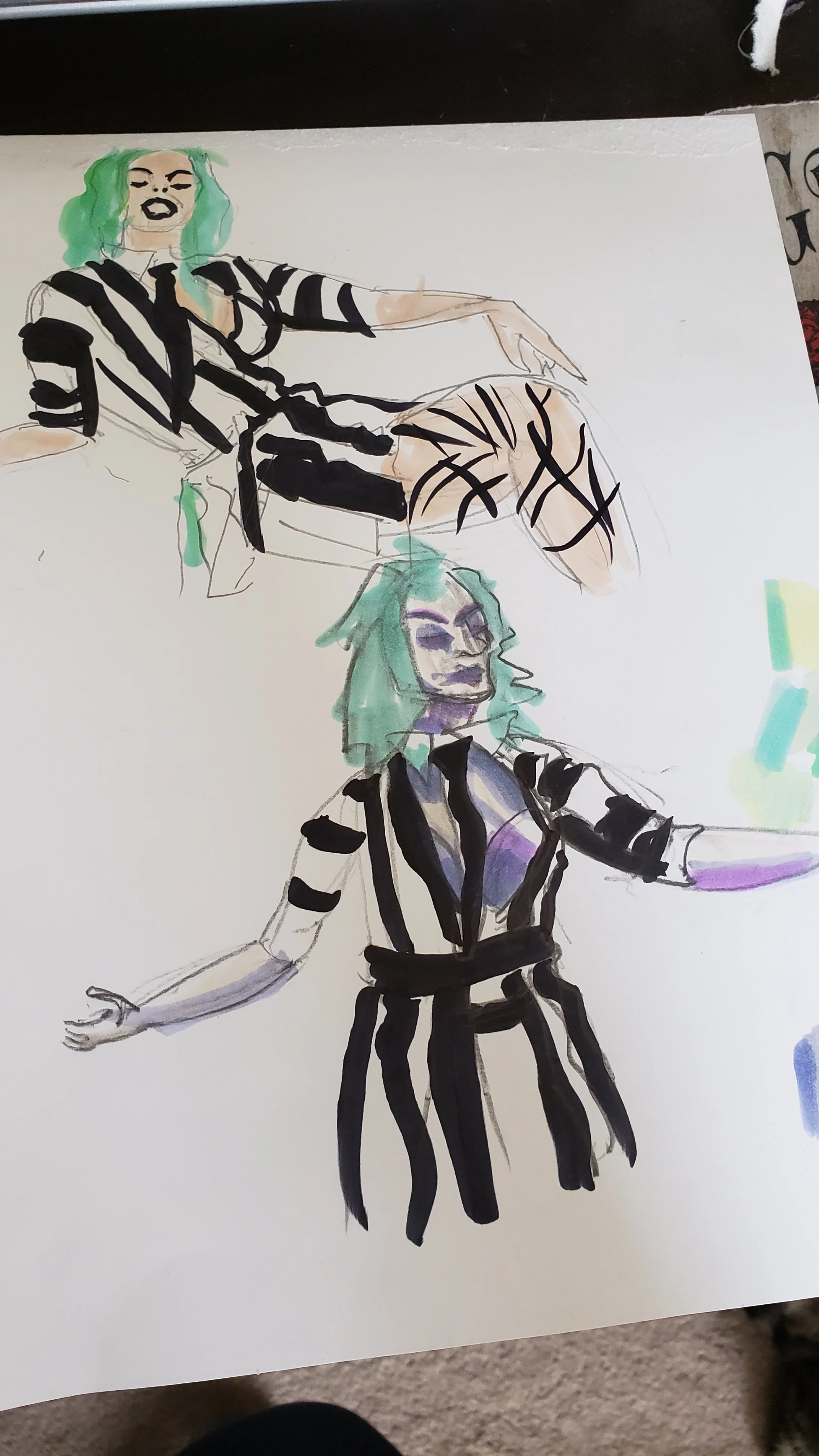 A fashion illustration featuring two women with green hair and striped outfits. The woman in the foreground has her arms outstretched, wearing a black and white striped top with black high-waisted pants. The woman in the background has wavy green hair, wearing a similar striped outfit, sitting on a chair with one leg crossed over the other.
