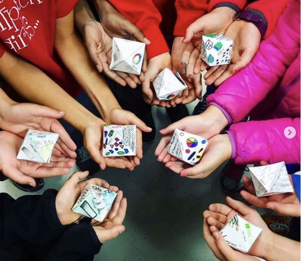 Young children's hands painting together at the studio table