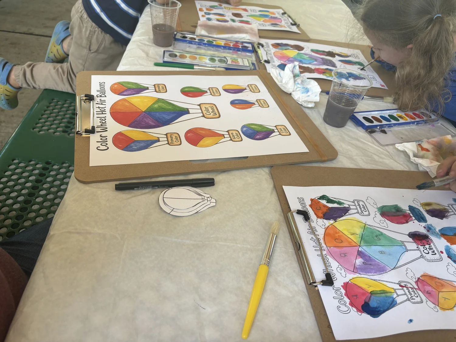 A table of completed and in-progress color wheel hot air balloon paintings