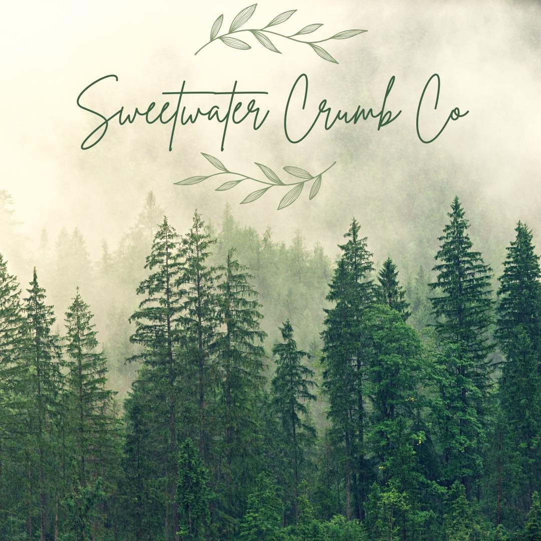 A foggy forest scene with tall evergreen trees and a light green color palette. The text 'Sweetwater Crump Co' is written in a handwritten style with decorative leaf accents at the top and bottom.