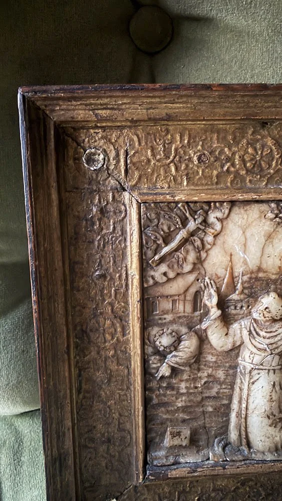 Corner of a gilded wood frame with a round nub, stamped rosette pattern, and worn gilding