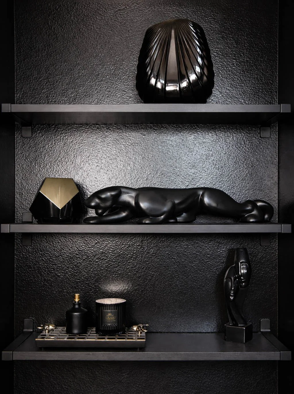 Black lacquer shelf styled with a panther sculpture, geometric object, and candle tray, 1980s postmodern glam
