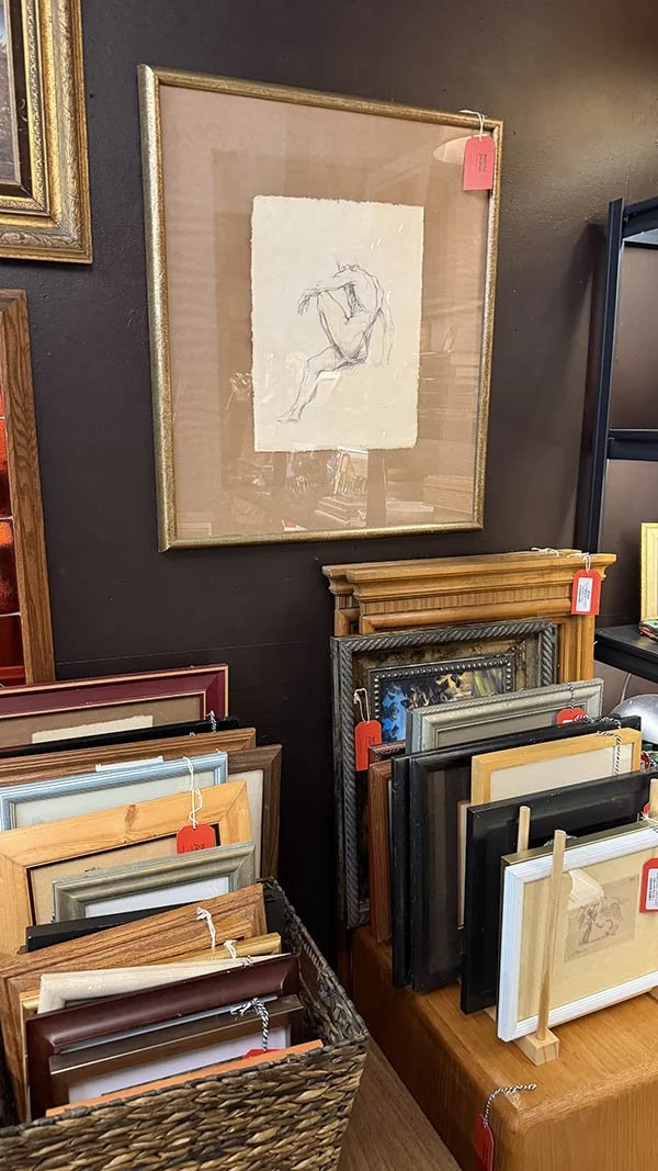 Antique picture frames stored together in a bin, un-curated and ready for sourcing